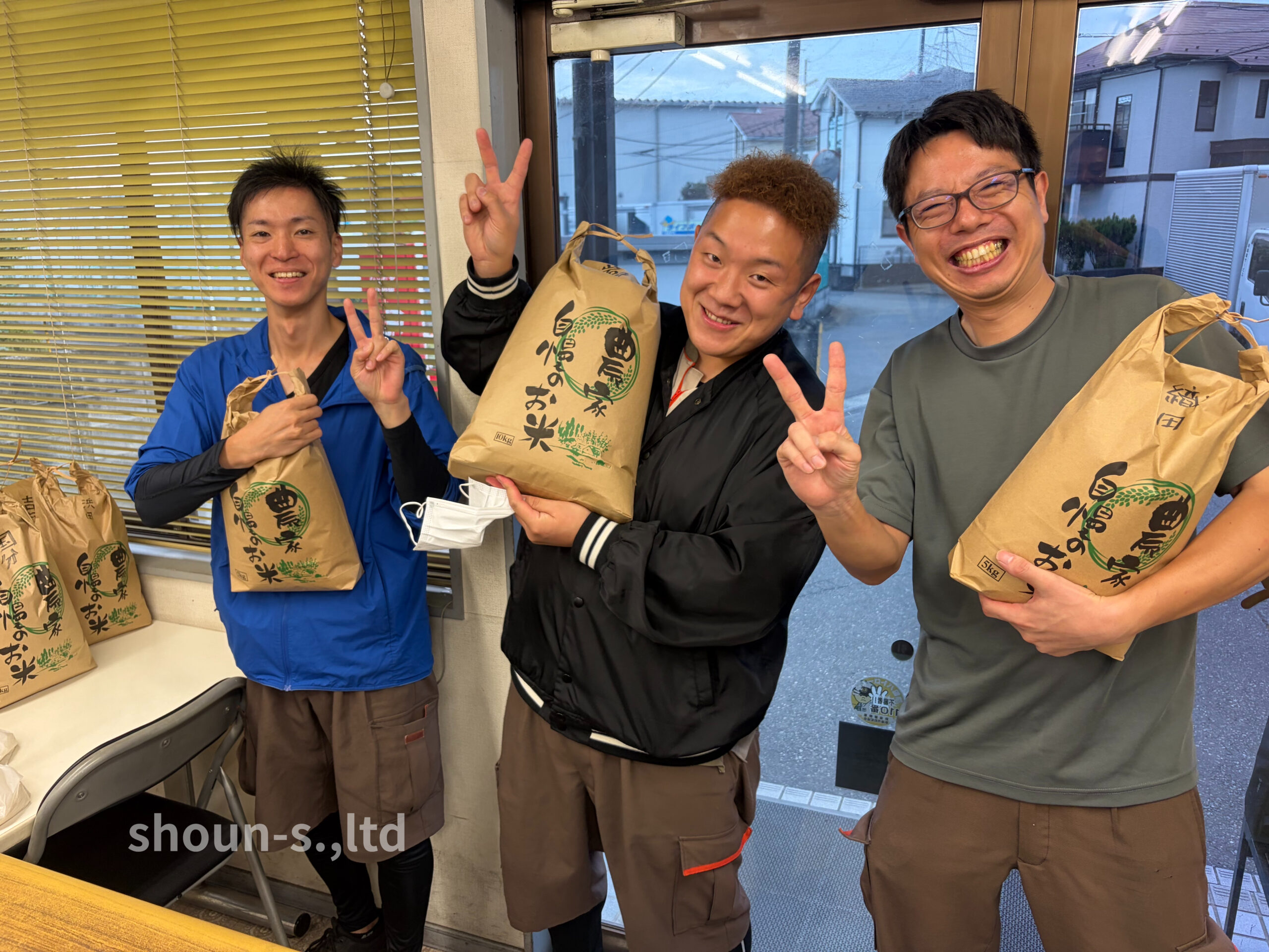 株式会社商運サービスの福利厚生5SPJで収穫・精米された念願の新米を手にして笑顔を見せる社員と家族（埼玉県新座市・東京都）