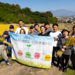 5月の田植え体験で苗を手作業で植え付ける商運サービスの社員