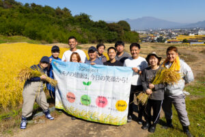 5月の田植え体験で苗を手作業で植え付ける商運サービスの社員